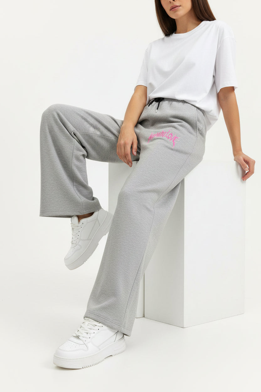 ZotRage grey cotton joggers featuring a wide-leg fit and a pink No More Love graphic print on the front
