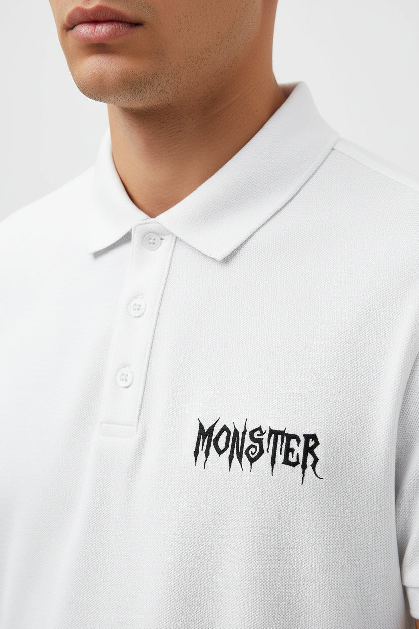 ZotRage white cotton Airtex polo shirt with a textured finish, structured collar, and black Monster logo embroidery.